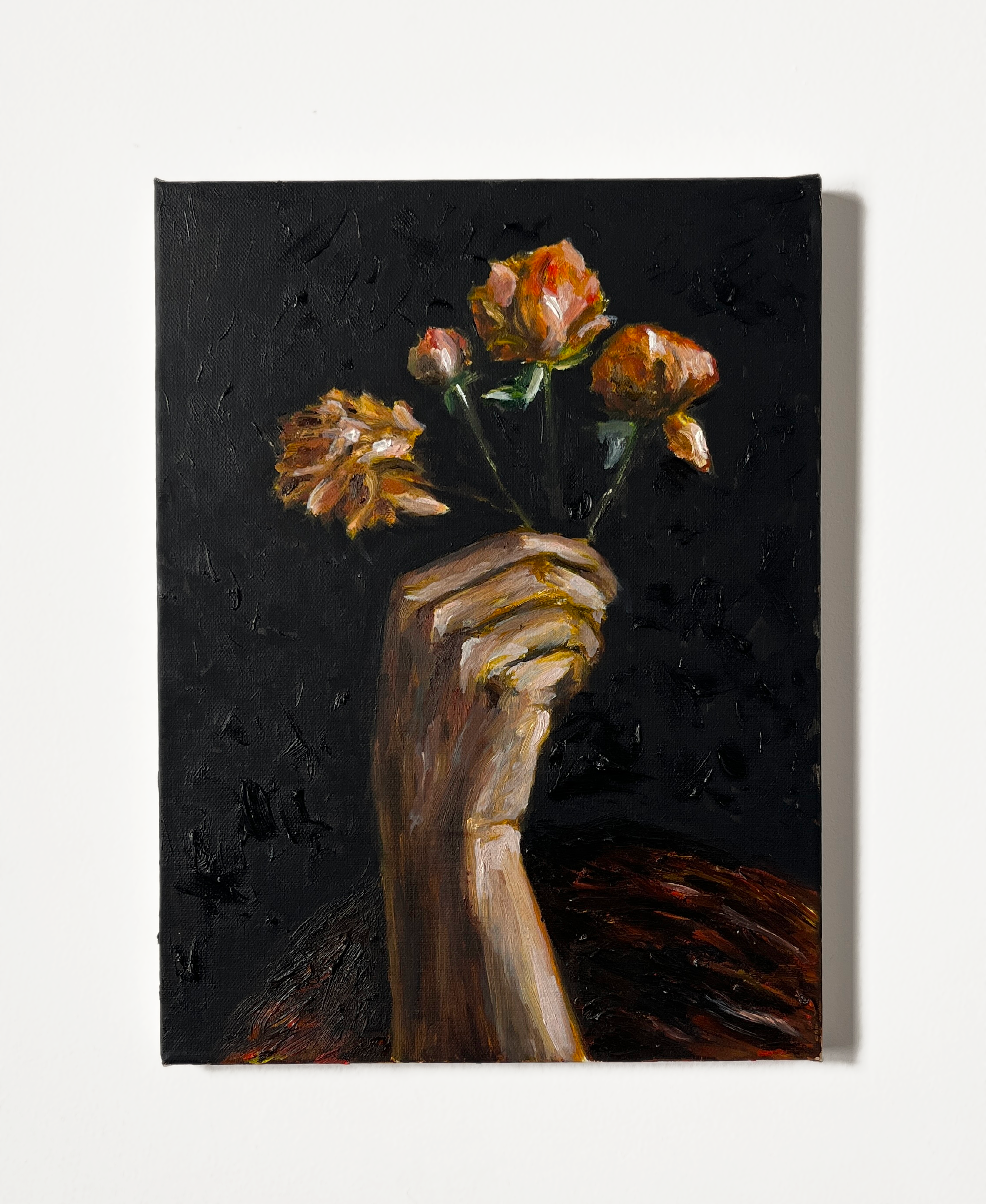 An oil painting depicting a hand firmly gripping a small bouquet of wilted orange roses against a dark, textured background. The hand appears tense, with visible veins and knuckles, rendered in earthy tones with expressive brushstrokes. The flowers, though still vibrant, show signs of decay, with petals curling inward and edges darkening. The background is rough and abstract, with deep black tones that contrast starkly with the warm hues of the hand and flowers. The painting has a dramatic, almost melancholic atmosphere, evoking themes of impermanence, resilience, and emotional intensity. oil painting, expressive realism, dark background, wilted flowers, hand, tension, contrast, texture, decay, emotional, dramatic lighting, chiaroscuro, symbolism, organic forms, rich brushstrokes, depth.